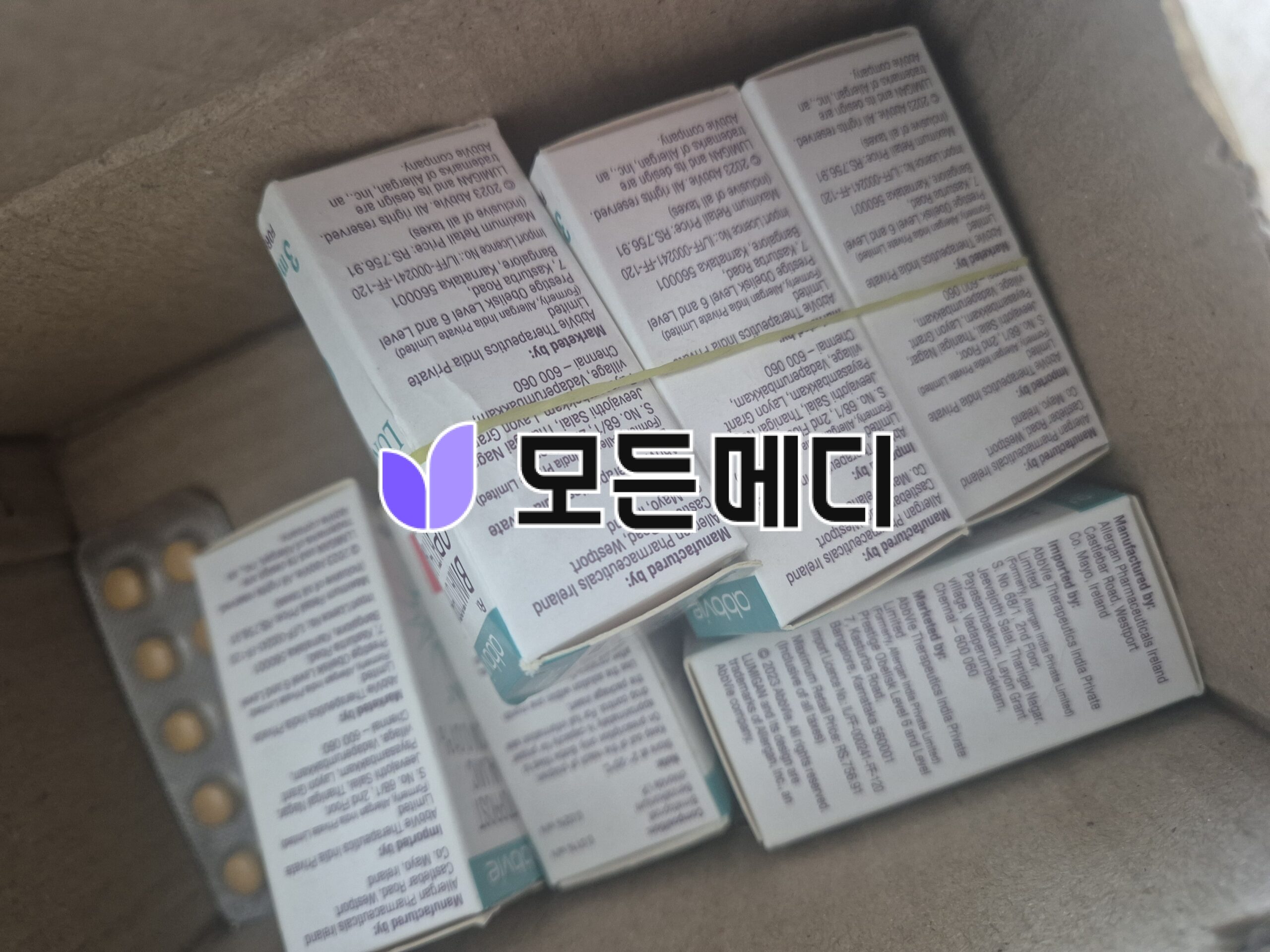 Several small medicine boxes with printed text tucked inside a cardboard container; labels are visible but unreadable up close (informational).