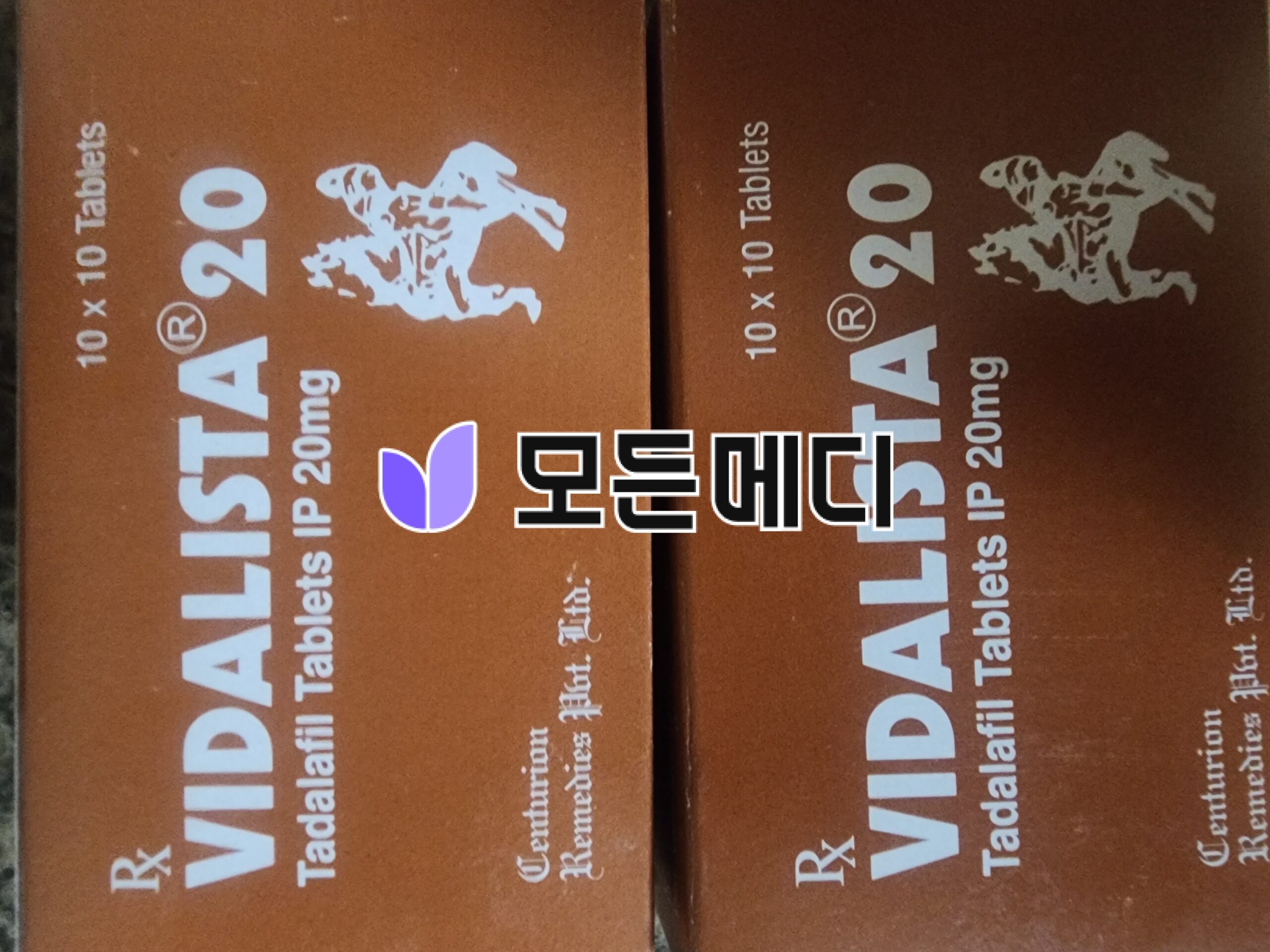 Two brown cardboard boxes placed side by side with white printed text and a small purple logo.