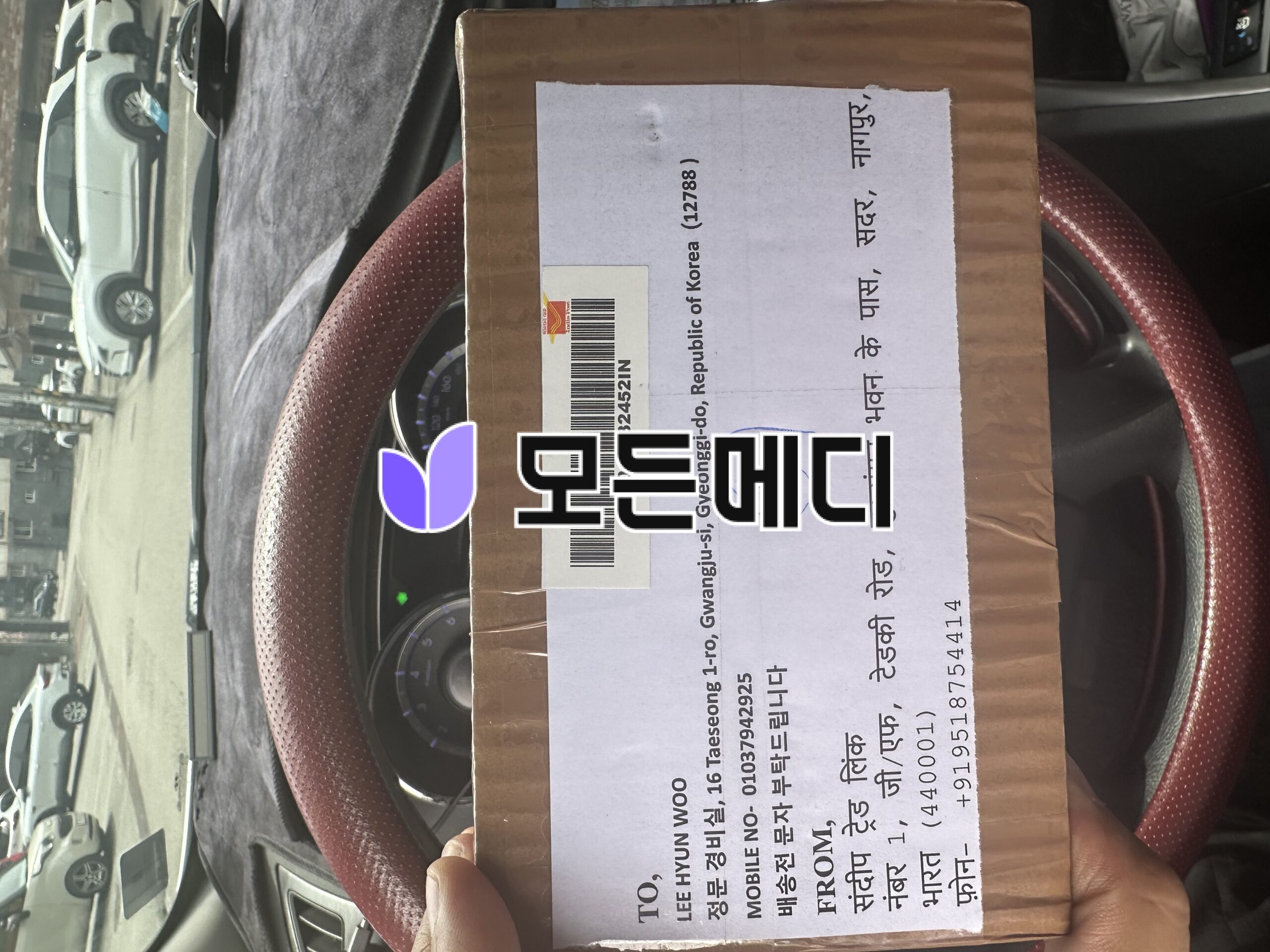 Brown cardboard package on a red car seat with a white shipping label and barcode visible